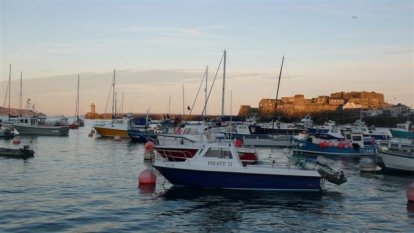 De wir-war van bootjes op weg naar het wachtponton van St.Peter  Port